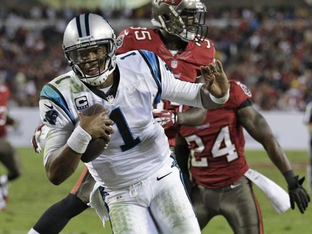 Carolina quarterback Cam Newton (1) scores on a 6-yard touchdown run after getting past Tampa Bay safety Kelcie McCray (35) and cornerback Darrelle Revis (24) during the third quarter on Thursday.