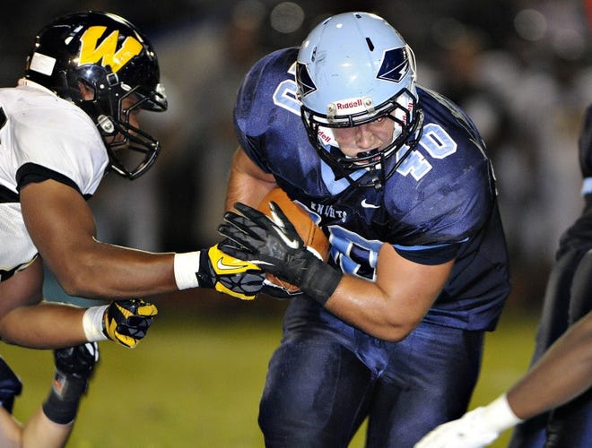 Archbishop Wood defensive end Nafezz Brown-Carter (left) moves to stop North Penn full back Luke Berry (40) for a short gain at North Penn High School in Towamencin in September.