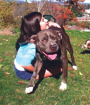 Kelly Vaught hugs Tank, a shelter dog her family is fostering.