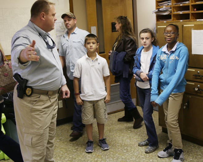 Lt. Dennes Hutto, left, gives a tour at the Parker Police Department on Friday to, from right, Amaya Ghant, 10, Brooke Key, 10, and Mark Doughty, 10.