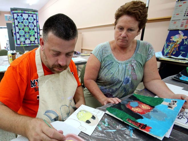 Ron Long Jr. paints a follow-up piece with help from Jenny Grenke, president of the Frostproof Art League, during a Wet Paint class on Oct. 17. The art league provides classes for developmentally and physically delayed adults each week.