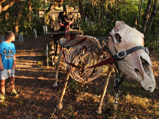 People look over a horse drawn hearse on one of the trails at "A Nightmare on Pine Street," which is being presented for Halloween by Wayne's World of Paintball, along with the Ocala Jaycees Haunted Trail, at Wayne's World of Paintball on South Pine Avenue in Ocala, Fla. on Thursday, Oct. 17, 2013.
