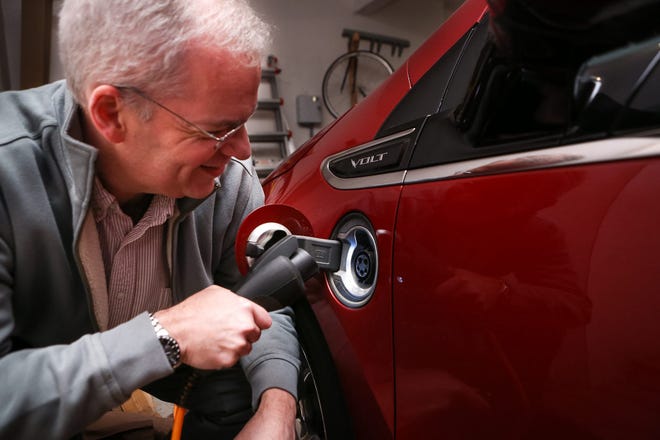 David McCarthy, of Hopkinton, plugs in his Chevy Volt electric car at his home in Hopkinton on Wednesday.
