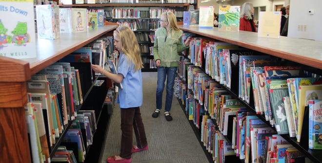 Katharine Quinn, 7, left, and Mary Quinn, 11, check out the children's section of the new library.