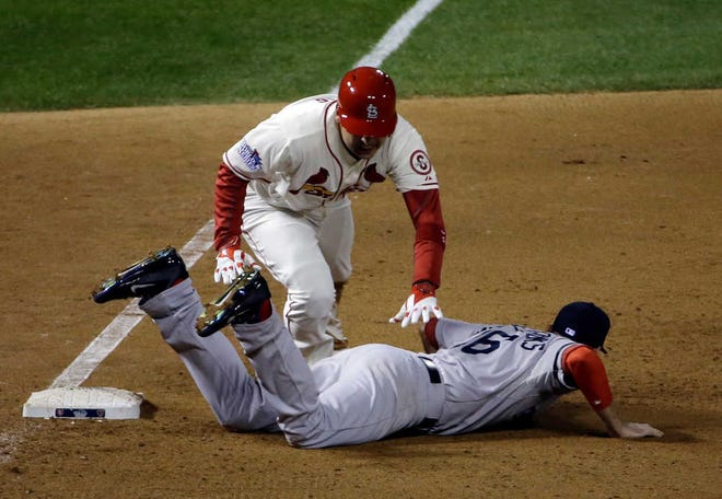 St. Louis Cardinals' Allen Craig gets tangled with Boston Red Sox's Will Middlebrooks during the ninth inning of Game 3 of baseball's World Series Saturday, Oct. 26, 2013, in St. Louis. Middlebrooks was called for obstruction on the play and Craig went in to score the game-winning run. The Cardinals won 5-4 to take a 2-1 lead in the series. (AP Photo/David J. Phillip)