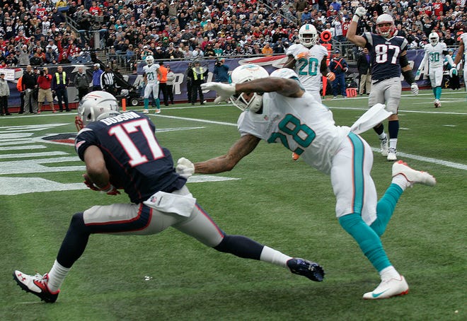 Patriot Aaron Dobson catches a Tom Brady 14 yard pass in the third quarter under tight coverage from Miami's Nolan Carroll for a touchdown, then celebrates with his teammates. Sunday, Oct. 27, 2013.