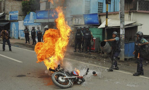 Bangladeshi police officers try to douse the flames on a motorcycle allegedly ignited by opposition activists during a general strike in Rajshahi, Bangladesh.