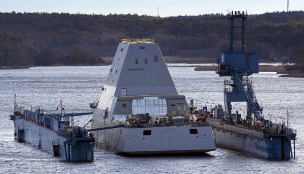 The first-in-class Zumwalt, the largest Navy destroyer ever, floats off a submerged dry dock in the Kennebec River in Bath, Maine. The Zumwalt, on display yesterday, has a low profile to minimize its radar signature, making it stealthier than other warships.
