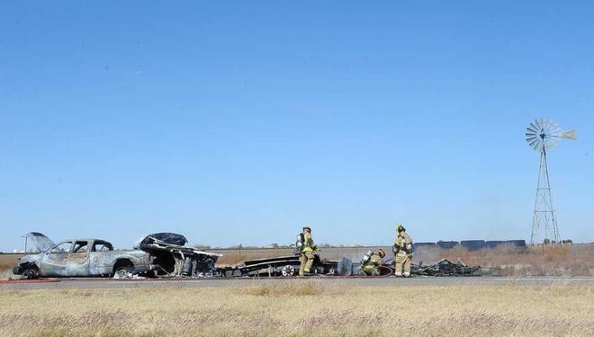 Firefighters work the scene of a fire involving a truck and trailer Wednesday in the westbound lane of Interstate 40 near the Carson County line.