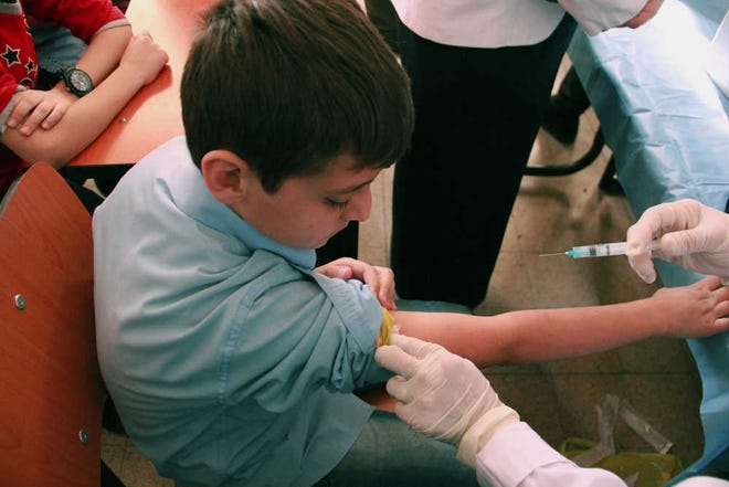 A Syrian student receives a vaccination as part of a UNICEF-supported vaccination campaign at a school in Damascus, Syria. The U.N.'s health agency said Tuesday it has confirmed 10 polio cases in northeast Syria, the first confirmed outbreak of the diseases in the country in 14 years, with a risk of spreading across the region.