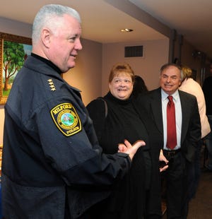 New Milford Town Administrator Richard Villani, right, with his wife, Linda, talk with Police Chief Tom O'Loughlin at a reception for Villani at Town Hall Friday.