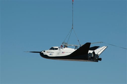 In this Aug. 22, 2013 photo made available by NASA, the Sierra Nevada Corporation's Dream Chaser spacecraft is carried by a helicopter during a test in Sparks, Nev.