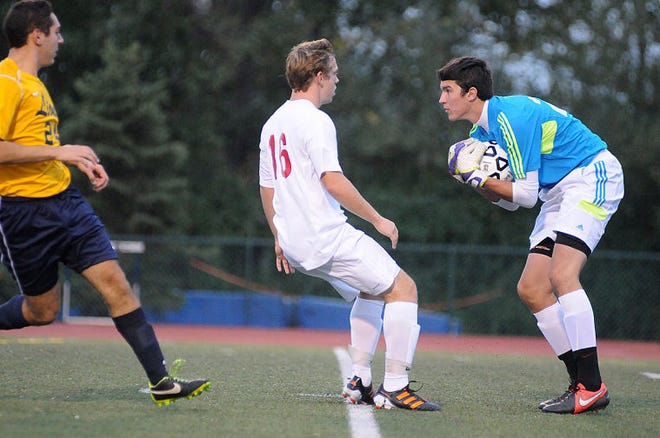 Lower Moreland goalkeeper stops the ball from Holy Ghost Prep's Adam Snyder (16) during their game on Thursday night against Lower Moreland at Council Rock North. Holy Ghost won 1-0.