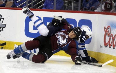 Colorado Avalanche right wing Steve Downie , front, gets tangled up with Winnipeg Jets defenseman Dustin Byfuglien while fighting for control of the puck in the second period of an NHL hockey game in Denver on Sunday, Oct. 27, 2013. (AP Photo/David Zalubowski)