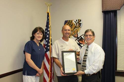 Dr. Jay Perniciaro and Office Manager Sheila Theriot receiving a Proclamation from Gonzales Mayor Barney Arceneaux.