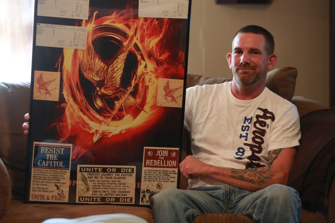 Robert Potter is shown here with some of the memorabilia he collected as an extra in the "Hunger Games' movies