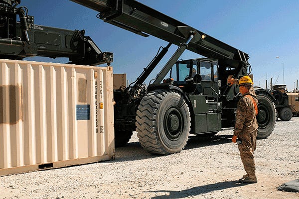 Spc. Casey E. Sleeman, a native of Sioux, S.D., and a cargo specialist, ground guides and conducts arm and hand signals for Spc. Kevin E. Berry, a native of Grantsburg, Wis., and a materials handler equipment operator, as Berry prepares to pick up a container with a Kalmar RT-240 Rough Terrain Container Handler. Both Soldiers are with the 203rd Inland Cargo Transfer Company, 157th Combat Sustainment Support Battalion in support of the 1st Theater Sustainment Command and Task Force Lifeliner. The Soldiers ar