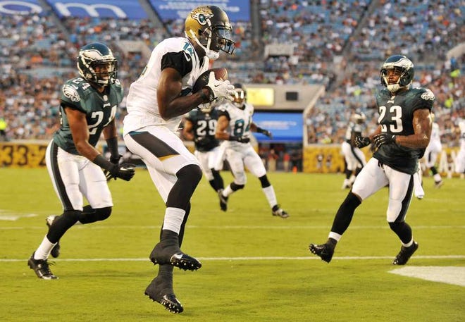 Bob.Self@jacksonville.com Jaguars wide receiver Justin Blackmon pulls in a touchdown pass between Eagles defenders in the first quarter at EverBank Field on Aug. 24.
