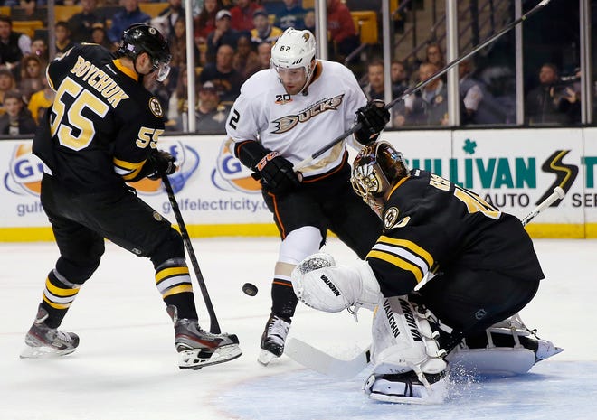 Boston Bruins' Johnny Boychuk, left, tries to clear the puck as Anaheim Ducks' Patrick Maroon, center, looks for control in front of Bruins goalie Tuukka Rask in the first period of an NHL game in Boston, Thursday, Oct. 31, 2013.