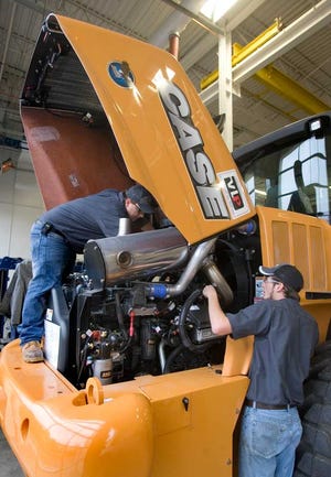 George Knight, left, and Miles Frye, first-year students in the diesel technology program at Washburn Tech, look over the engine of a CASE Wheel Loader.