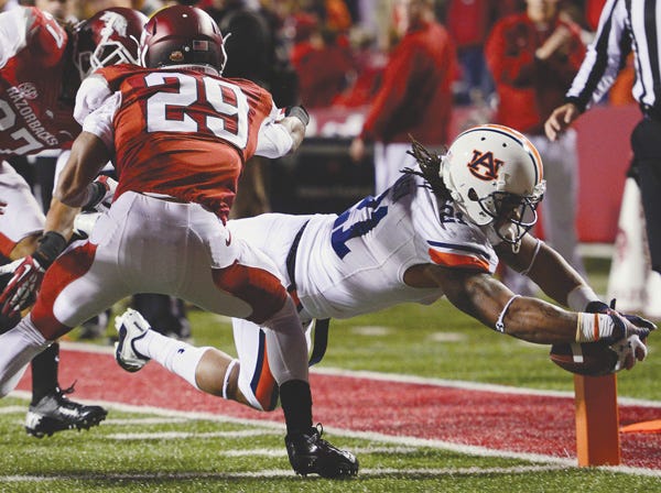 Auburn's Tre Mason dives for a touchdown while Arkansas' Jared Collins (29) and Alan Turner defend Saturday. (Todd Van Emst | Auburn University)