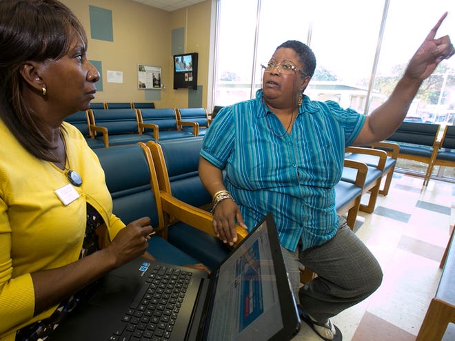 Anna Wilson, left, the only Navigator at the Heart of Florida Health Center for both Marion and Sumter Counties, helps Wanda Forbes sign up for health care under the Affordable Care Act Wednesday afternoon, October 30, 2013. Anna helped by answering questions for Forbes who hasn't been able to get on the website like much of the rest of the U.S.. Heart of Florida is designated as the place for people to sign up for both Marion and Sumter counties.