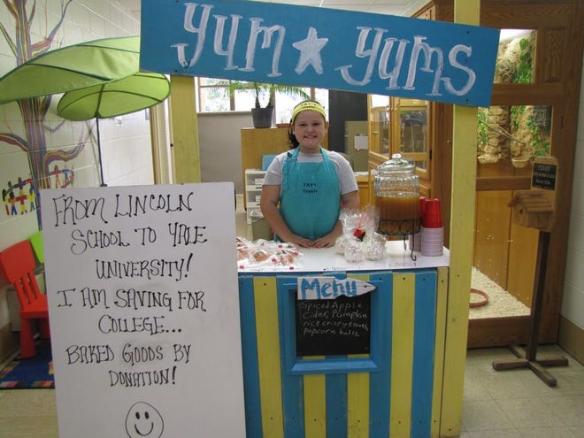 Taylor Tinsman, 8, sells pumpkin rice crispy treats, popcorn balls and apple cider at the Lincoln Elementary School’s bazaar Saturday to raise money for Yale University. After deciding she wants to go to Yale about a year and a half ago, Taylor has been selling baked goods ever since.