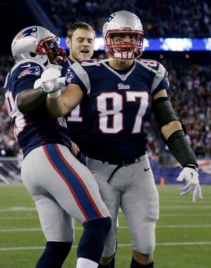 Patriots tight end Rob Gronkowski (87) celebrates with LeGarrette Blount (left) after scoring a touchdown during New England's 55-31 win over the Steelers on Sunday.