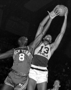 In this March 18, 1966, file photo, Philadelphia 76ers’ Wilt Chamberlain, right, grabs a rebound over New York Knicks’ Walt Bellamy. Bellamy, the Hall of Fame center who averaged 20.1 points and 13.7 rebounds in 14 seasons in the NBA, died Saturday. He was 74.