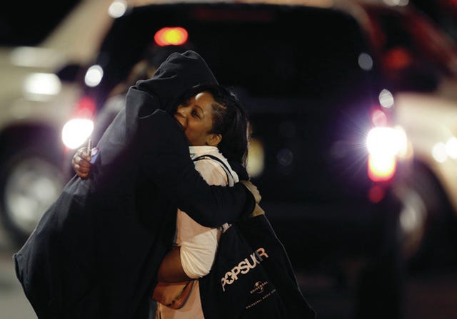 A woman, right, is reunited with a man in the parking lot of Garden State Plaza Mall following reports of a shooter, Tuesday, Nov. 5, 2013, in Paramus, N.J. Hundreds of law enforcement officers converged on the mall Monday night after witnesses said multiple shots were fired there. AP Photo/Julio Cortez