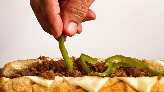 Sal Baldino adds the works to his Famous Philly Cheesesteak at Baldino s Italian Restaurant in Tequesta. The cheesesteaks with the works sell for $8.95 for a small and $10.99 for a large. (Photo by Libby Volgyes/Special to the Palm Beach Post)