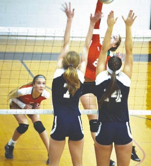 Cheboygan's Kelsey Reager (2) goes up for a kill attempt while Roscommon's Reagan Moffit (7) and Lauren Shores (14) attempt to block during the second set of Wednesday's Class B district semifinal matchup at Cheboygan. Cheboygan's Corrie Bongard (far left) looks on during the play.