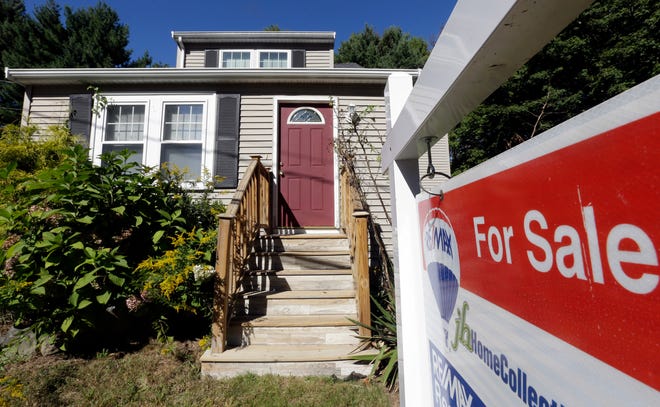 A for sale sign hangs in front of a house on Sept. 18 in Walpole, Mass. A measure of U.S. home prices rose only slightly in September from August, a sign that prices are leveling off after big gains earlier this year.