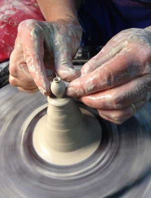 Local potter Carolyn Curran creates a miniature pot on the wheel.