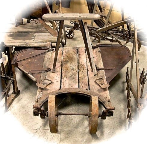 What Is It?  Try to ignore the other tools displayed around this week’s item. Is it a sled, a go-cart, an airplane? No, it was used on a farm where someone with an inventive mind needed help to ease a back-breaking job. What Is It?