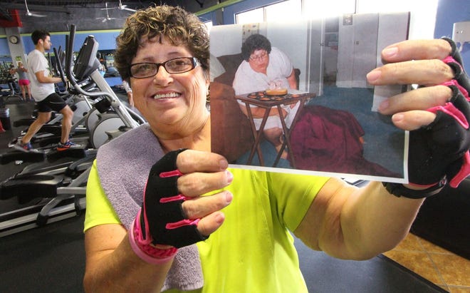 Terry Bolton, working out at Get Fitness in Port Orange, holds a photograph of herself recently before she lost 85 pounds. Bolton adopted a healthier lifestyle after being diagnosed with breast cancer.
