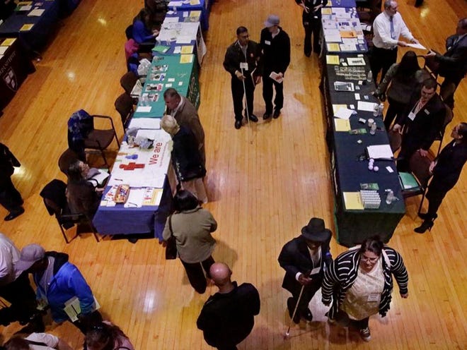 Job seekers and their volunteer guides attend a job fair for the visually impaired in the former Radcliffe College gymnasium, at Radcliffe Yard in Cambridge, Mass., on Thursday. 
 (AP PHOTO)