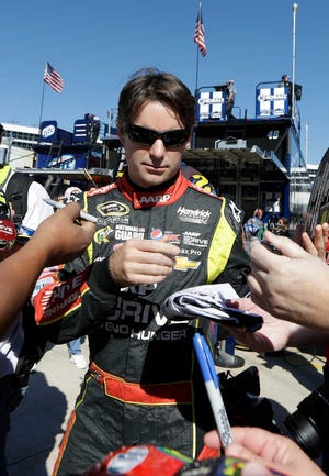 Jeff Gordon signs autographs for fans while heading to the garage before practice in Fort Worth, Texas, on Friday.