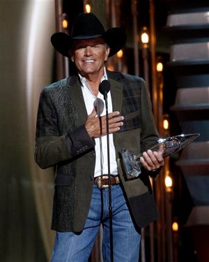 George Strait accepts the award for entertainer of the year at the 47th annual CMA Awards at Bridgestone Arena on Wednesday, Nov. 6, 2013, in Nashville, Tenn. (Photo by Wade Payne/Invision/AP)