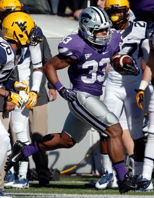 Kansas State running back John Hubert (33) gets past West Virginia cornerback Travis Bell (26) and safety Darwin Cook, left, during the first half of an NCAA college football game in Manhattan, Kan., Saturday, Oct. 26, 2013. (AP Photo/Orlin Wagner)