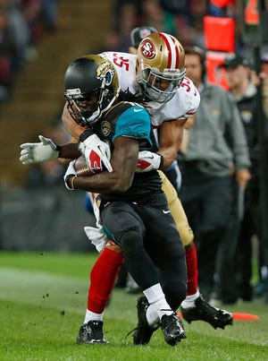 Jacksonville Jaguars running back Denard Robinson (16), is tackled by San Francisco 49ers free safety Eric Reid (35) during the NFL football game between San Francisco 49ers and Jacksonville Jaguars at Wembley Stadium in London, Sunday, Oct. 27, 2013. (AP Photo/Sang Tan)