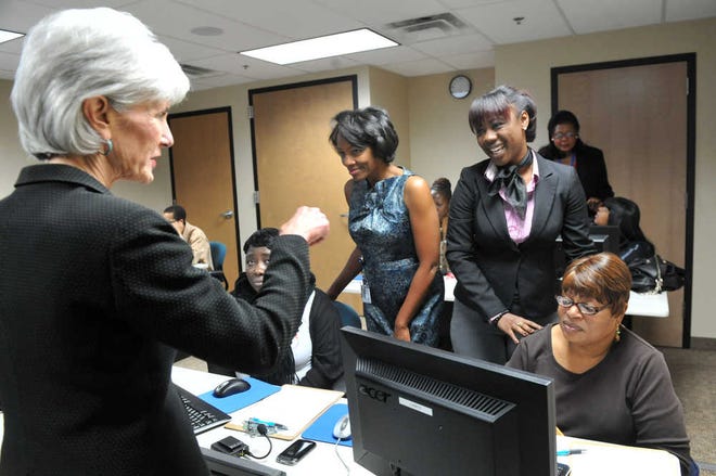 Health and Human Services Secretary Kathleen Sebelius meets Friday with Ebrun Crowder, left, and Anjanette Culbreth as they assist patients (seated, unidentified) during a visit in Atlanta. A new Obama administration rule requires insurers to cover treatment for mental health and substance abuse no differently than they do for physical illnesses.