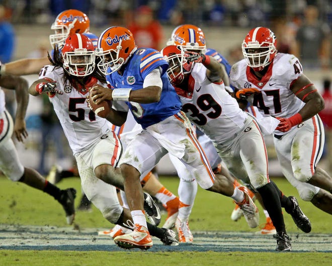 Florida quarterback Tyler Murphy (3) gets sacked by Georgia safety Corey Moore (39) as linebacker Ramik Wilson (51) pursues during an NCAA football game, Saturday, Nov. 2, 2013 at Alltel Stadium in Jacksonville, Fla. (AP Photo/Atlanta Journal-Constitution, Jason Getz) MARIETTA DAILY OUT; GWINNETT DAILY POST OUT; LOCAL TV OUT; WXIA-TV OUT; WGCL-TV OUT