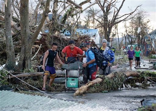 Residents try to seek shelter with their belongings following a powerful typhoon that hit Tacloban city, in Leyte province, central Philippines Saturday. Typhoon Haiyan, one of the most powerful typhoons on record, ripped through the region a day earlier, wiping away buildings and leveling seaside homes with massive storm surges.