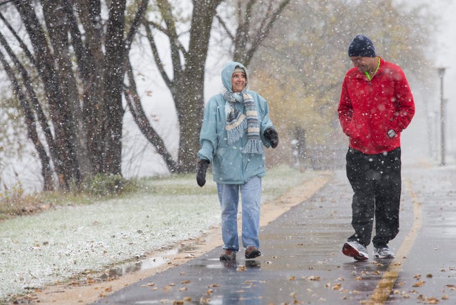 Carmella Maffei of Rockford and Phil Best of Byron walk down the Rock River Recreation Path in a light snow Monday, Nov. 11, 2013, in Rockford. Maffei walks three miles every day on the path, while Best is a year-round runner.