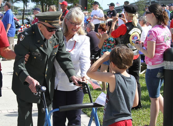 Five-year-old Landon McLain, of New Smyrna Beach, salutes retired Army Col. John Barck, 82, at New Smyrna Beach’s Veterans Day ceremony at Riverside Park on Monday.