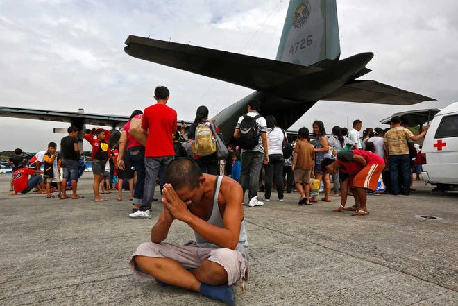 A survivor from Tacloban, central Philippines, which was devastated by Typhoon Haiyan, sits after disembarking a Philippine Air Force C-130 aircraft at the Villamor Airbase on Tuesday in Manila, Philippines.