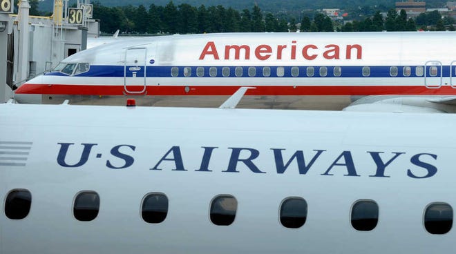An American Airlines plane and a US Airways plane are parked Aug. 13 at Washington's Ronald Reagan National Airport. On Tuesday, the Justice Department said it has reached an agreement to allow the merger of the two airlines. The agreement requires them to scale back the size of the merger at key airports in Washington and other big cities.