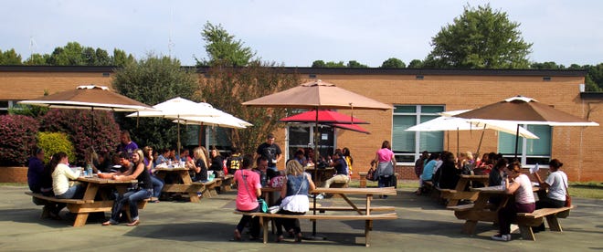 Kings Mountain High School students eat and do schoolwork outside during SMART lunch