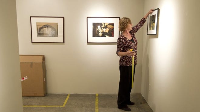 Tina Weitz hangs an exhibit at her Photo Methode Gallery at Flatbed.